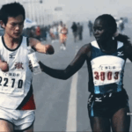 Elite runner Jaqueline Kiplimo helps a disabled Chinese athlete drink during the 2010 Zheng-Kai marathon.
